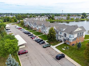 an aerial view of a row of houses next to a body of waterat The Harbours Apartments, Clinton Twp, MI